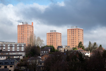 Fototapeta na wymiar Three orange buildings against dramatic sky