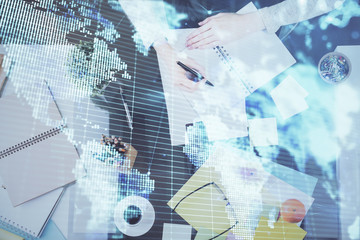 International business hologram over woman's hands taking notes background. Concept of success. Double exposure
