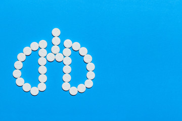 lungs symbol made of white round pills on a blue background with copy space.