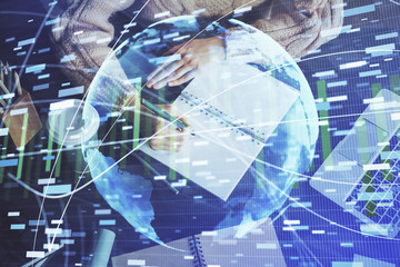 International business hologram over woman's hands taking notes background. Concept of success. Double exposure