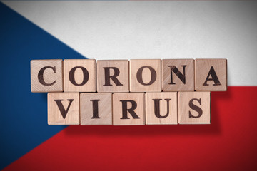 Flag of Czech Republic with wooden cubes spelling coronavirus on it. 2019 - 2020 Novel Coronavirus (2019-nCoV) concept, for an outbreak occurs in Czech Republic.