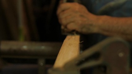 Carpenter using spokeshave hand planer on wood woodworking