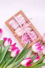 spring pink zephyrs with tulips on white background. concept zephyr flatlay with pink tulips