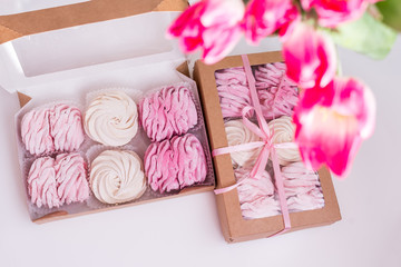 A box with homemade marshmallows and a bouquet of Tulip flowers on a white background. Space for text