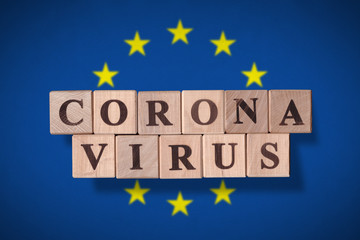 Flag of European Union with wooden cubes spelling coronavirus on it. 2019 - 2020 Novel Coronavirus (2019-nCoV) concept, for an outbreak occurs in Europe.