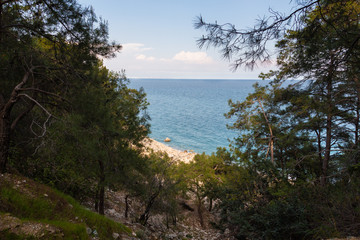 Fototapeta na wymiar A rocky path adown to the sea through the grove