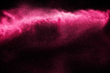 Pink powder explosion on black background.Pink dust splash cloud on dark background.