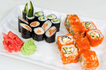 A complex of Japanese rolls with salmon and cucumber, wasabi and ginger