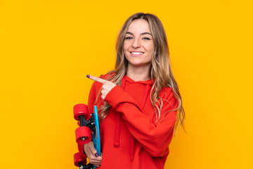 Young woman over isolated yellow background with a skate and pointing to the side