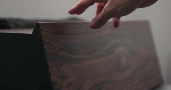 Slow motion man hand check walnut wood breadbox