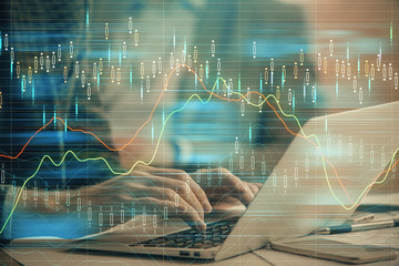 Double exposure of market chart with man working on computer on background. Concept of financial analysis.