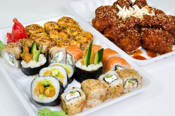 Big set lunch. Beef patties in sauce. Japanese sushi complex with salmon, cheese, chicken breast and cucumber, wasabi and ginger.