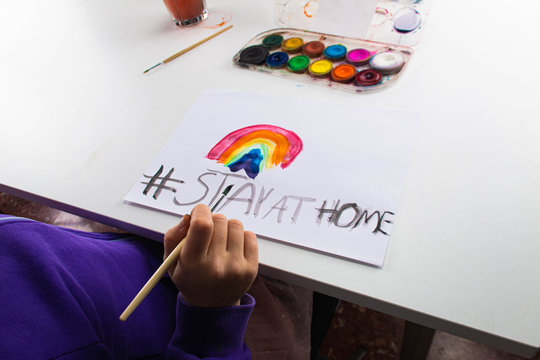 Child painting rainbow of hope, stay at home