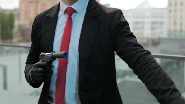Male hand with a gun with a silencer.
