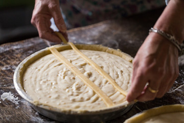 Preparation of Easter cake, also called Pastiera Napoli, typical homemade dessert, with eggs, flour, sugar and vanilla, wheat and colored sugared almonds