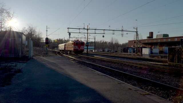 A short electric passenger train arriving to the train station in small Swedish town. No camera movements, filmed in slow motion at 4K.