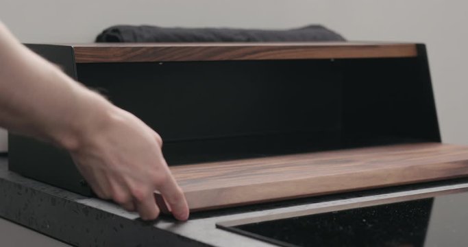 Slow motion man hand check walnut wood breadbox