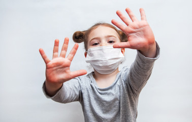 little girl in a disposable mask shows her hands. Coronavirus epidemic protection