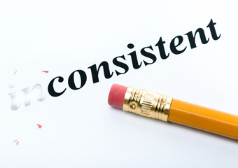Word " inconsistent " and pencil with eraser close-up