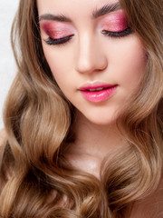 Fototapeta na wymiar Beautiful young blonde girl in monochrome makeup. Pink lips and eye shadow, delicate makeup.