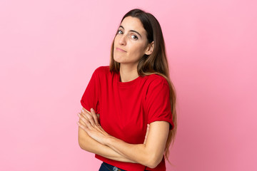 Fototapeta premium Young caucasian woman isolated on pink background making doubts gesture while lifting the shoulders