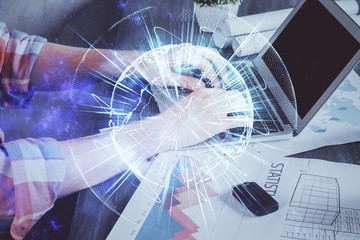 Double exposure of businessman working on laptop on background. International business hologram in front. Concept of success.