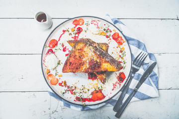 French toast stuffed with cream cheese, served with berry coulis, fresh strawberries and cookie...
