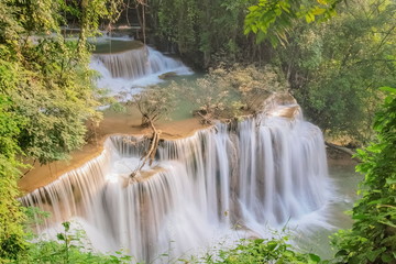 Beautiful soft silky water flowing on cliff rock with green forest background, Huanchanaburi, west of Thailand.y Mae Khamin Waterfall floor 4th (Chat Kaew) Ka