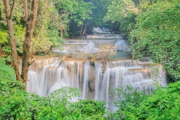 Beautiful soft silky water flowing on cliff rock with green forest background, Huanchanaburi, west of Thailand.y Mae Khamin Waterfall floor 4th (Chat Kaew) Ka