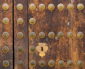 Detail of an old door in the cathedral of Almeria with bronze nails and locks.