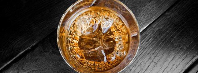 Glass of whiskey from the top on wooden darn background - obrazy, fototapety, plakaty