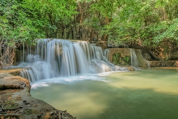Fototapeta na wymiar view of white silky water flowing around with green forest background, Huay Mae Khamin Waterfall floor 3th (Wang Nar Pha) Kanchanaburi, west of Thailand.
