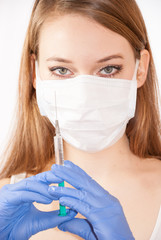 Nurse wearing mask holding syringe with vaccine against coronavirus covid-19 SARS-CoV-2