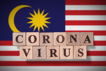 Flag of Malaysia with wooden cubes spelling coronavirus on it. 2019 - 2020 Novel Coronavirus (2019-nCoV) concept, for an outbreak occurs in Malaysia.