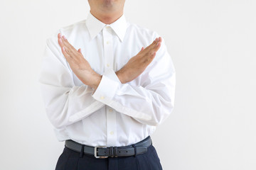 両腕でバツをしているワイシャツを着た男性