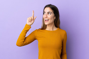 Young caucasian woman over isolated background intending to realizes the solution while lifting a finger up