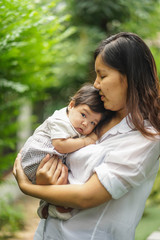 Mother holds baby in her arm with love.