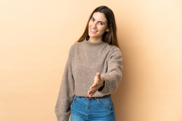Young caucasian woman over isolated background shaking hands for closing a good deal