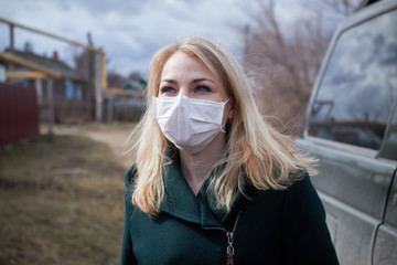 blonde girl in a medical mask on the street
