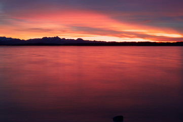 Fototapeta premium Glühendes Abendrot mit Blick auf die Alpen am Chiemsee nach dem Sonnenuntergang