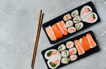 food delivery. set of sushi and rolls with salmon and shrimp. service food order online and home delivery during the COVID-19 coronavirus quarantine . concept layout 2 for the price of 1.