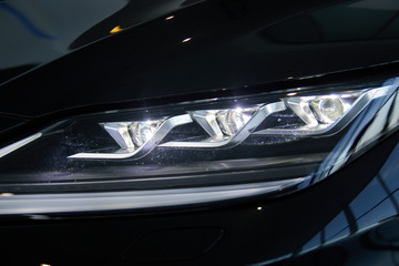 Obraz na płótnie Canvas Luminous headlight on a new car in the showroom