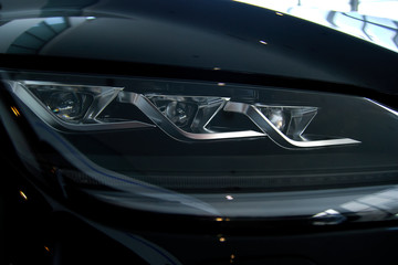 Obraz na płótnie Canvas Luminous headlight on a new car in the showroom
