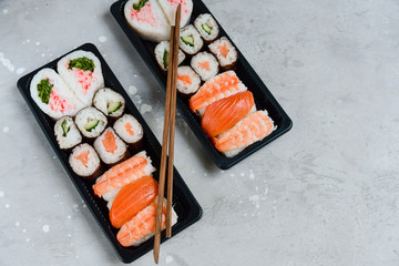 food delivery. set of sushi and rolls with salmon and shrimp. service food order online and home delivery during the COVID-19 coronavirus quarantine . concept layout 2 for the price of 1.