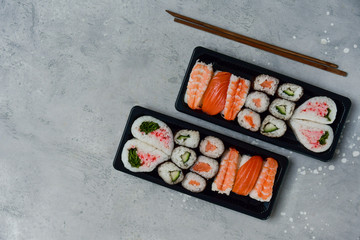 food delivery. set of sushi and rolls with salmon and shrimp. service food order online and home delivery during the COVID-19 coronavirus quarantine . concept layout 2 for the price of 1.