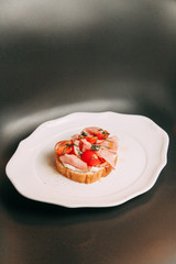 Fresh bread and tomatoes on bread. Bruschetta on a plate with bacon.