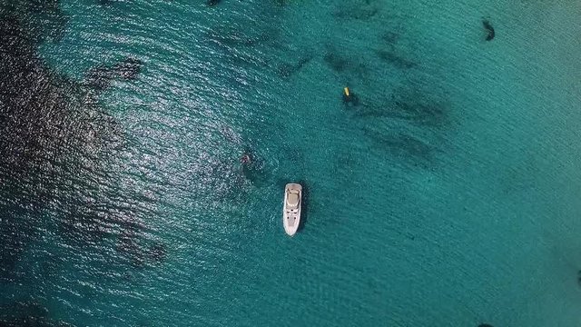 Scenic Sardinia coast of Maddalena archipelago with azure clear water. Boats and ships anchored, people swimming in sea. Aerial view.
