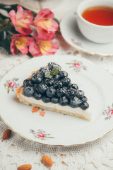  Slice of cake with berries and cream. A piece of blueberry cake on a white plate.