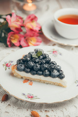  Slice of cake with berries and cream. A piece of blueberry cake on a white plate.