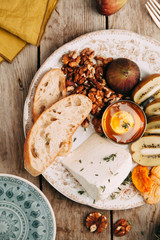 Flatley cheese plate with figs. Snacks for the company. Set of cheeses on a plate with honey and nuts.